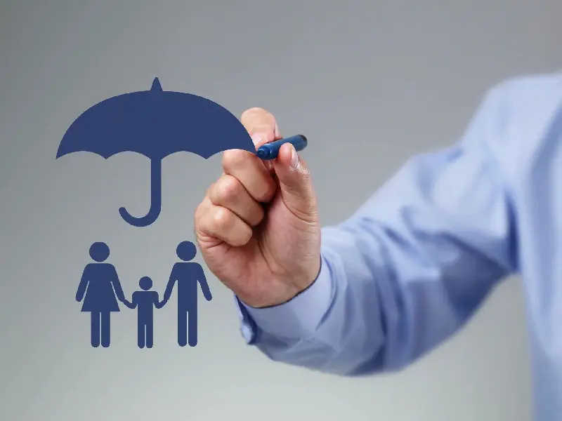 A person drawing an umbrella over their family.